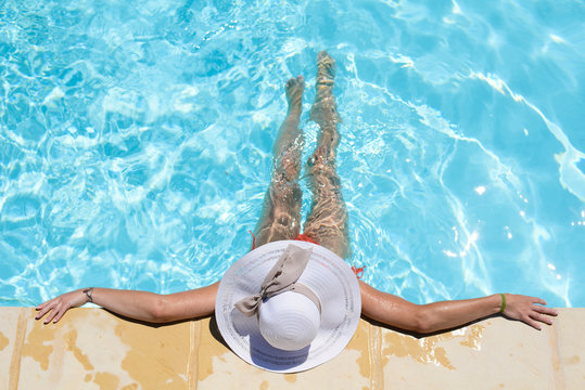 beautiful young woman in the swimming pool on a sunny summer day
