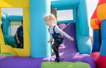 Pretty little blond girl playing on a slide