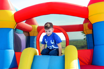 Fototapeta na wymiar Young boy playing on a bouncy castle