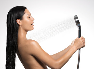 woman in shower washing body under the stream of water