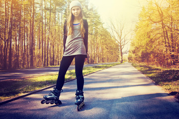 Teenage girl on roller skates at summer.