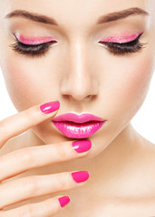 eautiful woman face with pink makeup of eyes and nails.