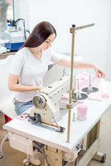 girl seamstress sew on the sewing machine