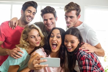 Obraz premium Happy friends making faces while taking selfie at home