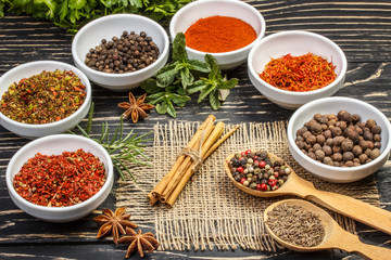 Colorful aromatic Indian spices and herbs on an old  oak wooden brown backgrownd
