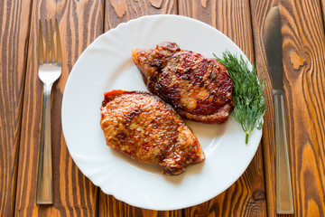 grilled meat with dill on a white plate