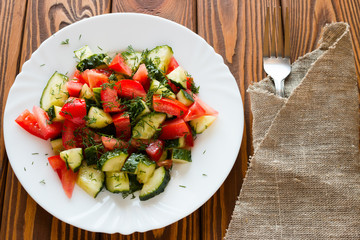 vegetarian salad on a white plate next to fork
