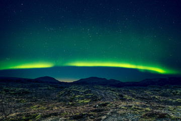 Northern lights over distant mountains