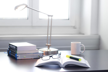 Schreibtisch / Arbeitsplatz mit Büchern, Brille, Taschenrechner und Ordnern