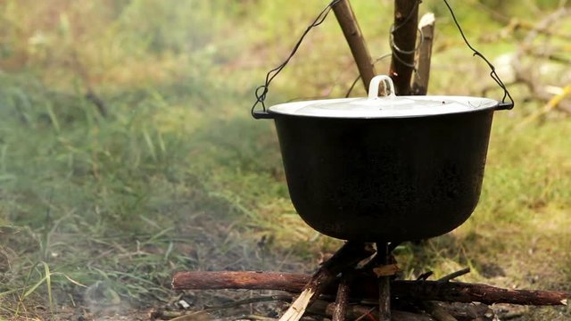 Pot of boilling Ukha (fish-soup) on the campfire