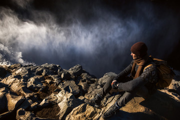 Tourist at the edge of waterfall
