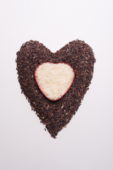 Heart shape from mix of jusmin rice and riceberry rice on white background