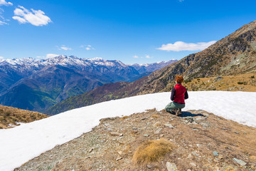 Hiker kneeling and resting on the scenic mountain summit