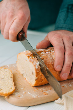 Male hands cutting wheaten bread