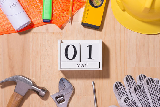 May 1st. Image of may 1 white blocks wooden calendar with construction tools on the table. International Workers' Day. Labor day concept.