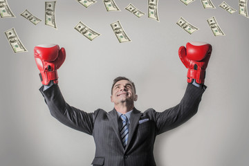 victorious businessman raised his hands in Boxing gloves