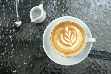 Cups of latte art coffee on black table