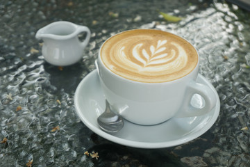 Cups of latte art coffee on black table