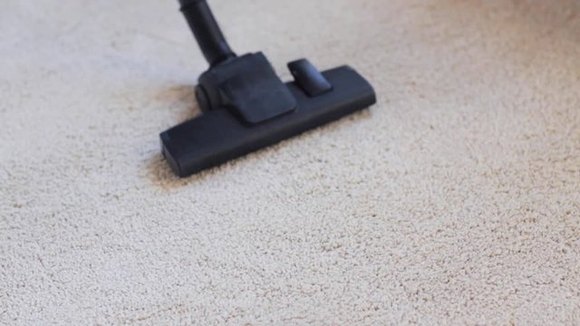 Woman With Vacuum Cleaner Cleaning Carpet At Home