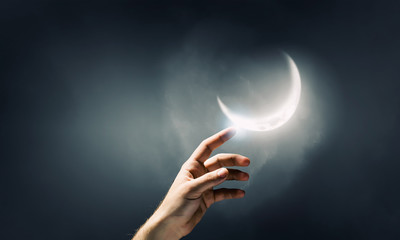 Finger reaching moon planet