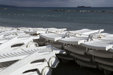 A stack of beach lounges out of season. Limassol's seafront promenade. Cyprus.