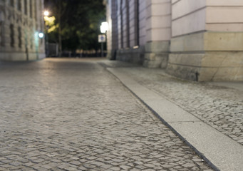 empty brick road at night with blurred background, historic midtown of Berlin, Germany, Europe
