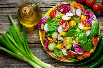 Gordijnen Fresh vegetable salad on wooden background © Daniel Vincek