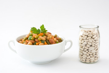 White beans with vegetables in a bowl isolated on white background