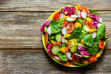 Fresh vegetable salad on wooden background