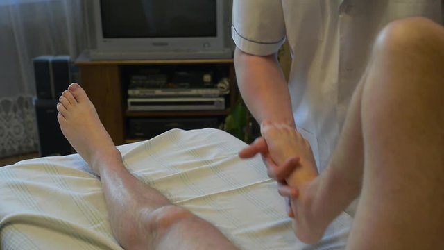 specialist is making a massage to disabled person 
