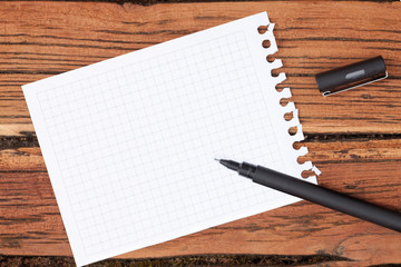 Squared Paper and Pan lying on a Wooden Surface