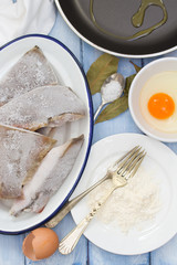 frozen fish with egg, powder on wooden background