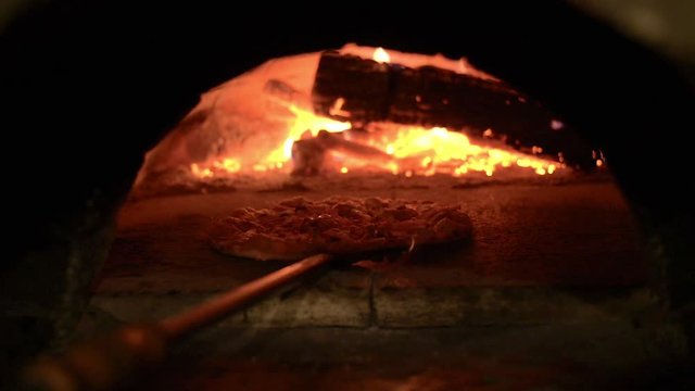 cooking a pizza in a wood fired oven