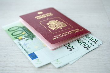 Russian passport lies on a pile of euro banknotes