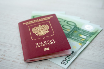 Russian passport lies on a pile of euro banknotes