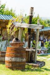 Old rusty wine press with oak barrel. © indigolotos