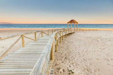 Wooden boardwalk to the beach. Idyllic scene - obrazy, fototapety, plakaty