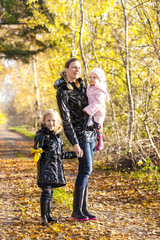 Fototapeta premium mother with her daughters in autumnal nature