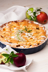 Homemade apple pie on a white wooden background.