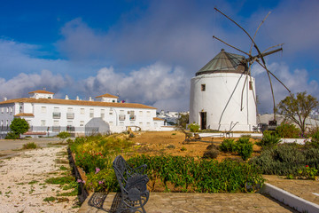 Historische Windmühle neben modernem Wohnhaus