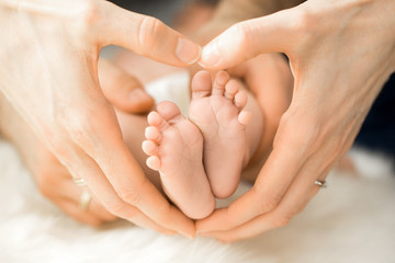 Obraz na płótnie Canvas Hand formt ein Herz um Baby Füße