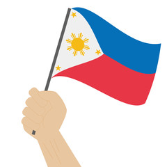 Hand holding and raising the national flag of Philippines
