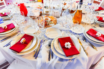 Fototapeta premium Table set for banquet with cutlery. Cotton flower decoration.