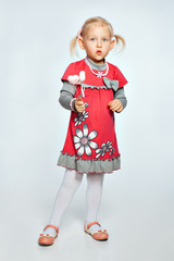 Baby girl is holding a toy heart and grimaces