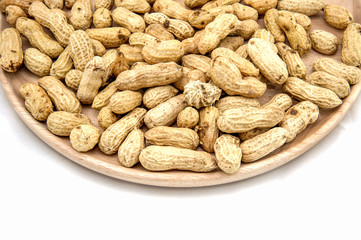 Wooden dish of nuts on white wooden background