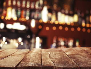 Empty wooden table and bokeh pub, bar of restaurant background.