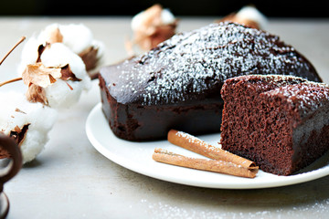 Tasty chocolate cake and cotton flowers