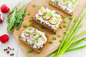 Delicious sandwiches with soft cream cheese and radish.  Vegetarian food. Top view, close-up.