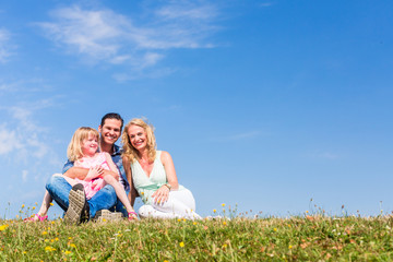 Mother, father, child, sitting in open air