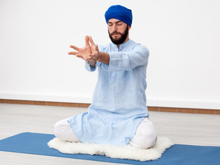 Meditation. Portrait of a young bearded yogi man in a turban with hands  folded in mudra on the...